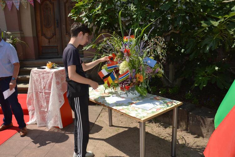 Einer für Alle, Alle für Einen - symbolisch werden die Fahnen der jeweiligen Länder in das Blumenbouquet gesteckt